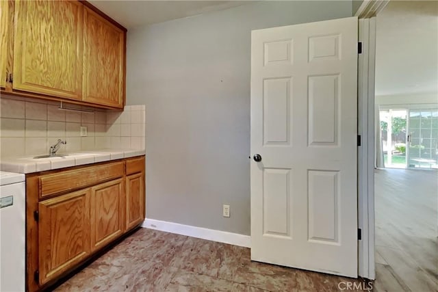 2100 Sherwood Ave Unit A, Modesto, CA 95350 - kitchen featuring tile counters, a sink, baseboards, and backsplash