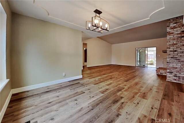 2100 Sherwood Ave Unit A, Modesto, CA 95350 - interior space with baseboards, vaulted ceiling, wood finished floors, and an inviting chandelier