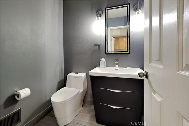 2100 Sherwood Ave Unit A, Modesto, CA 95350 - half bath featuring toilet, vanity, a textured wall, and visible vents