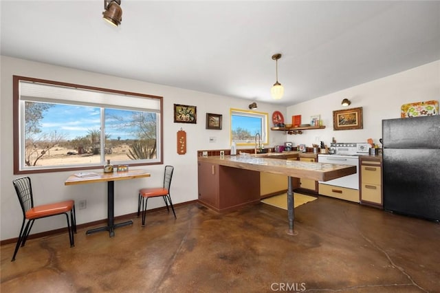 kitchen with baseboards, freestanding refrigerator, dishwashing machine, finished concrete floors, and a sink