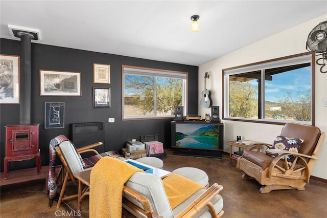 living area featuring a wood stove and baseboards