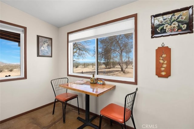 carpeted dining area featuring baseboards