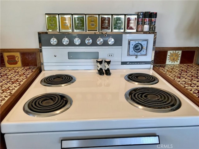 room details featuring tasteful backsplash, light countertops, and white electric range