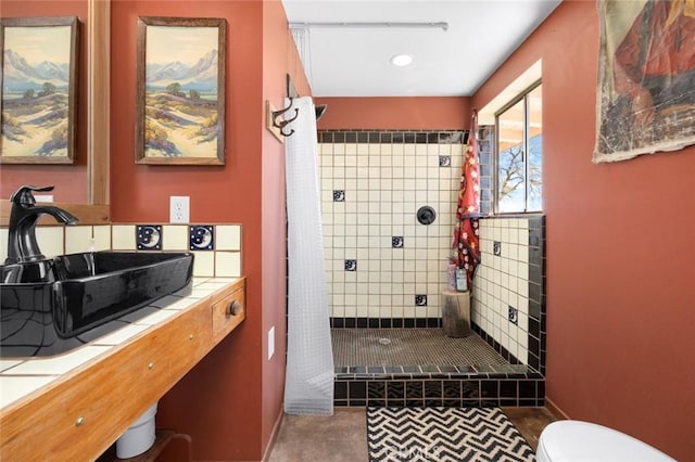 bathroom featuring baseboards, a sink, toilet, recessed lighting, and a stall shower