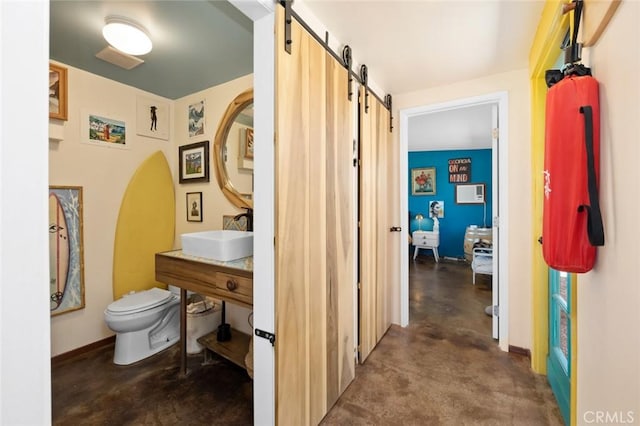bathroom featuring concrete floors, a sink, and toilet