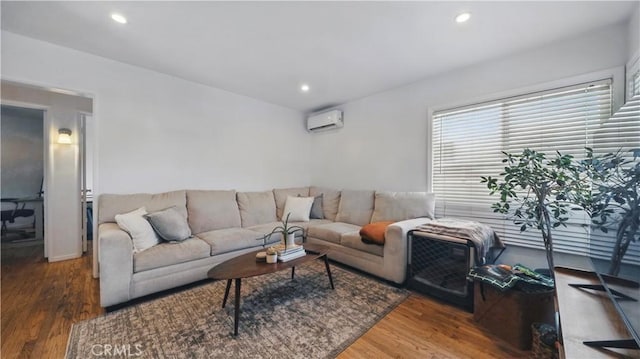 living area with a wall unit AC, recessed lighting, and wood finished floors