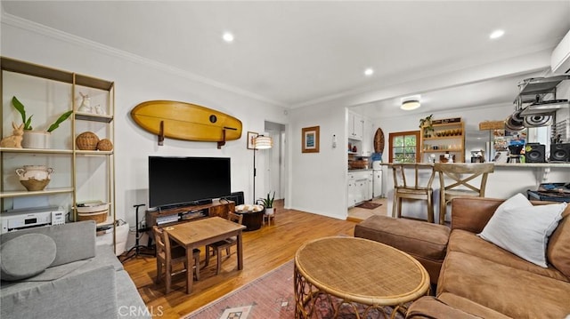 living room featuring recessed lighting, ornamental molding, and light wood-type flooring