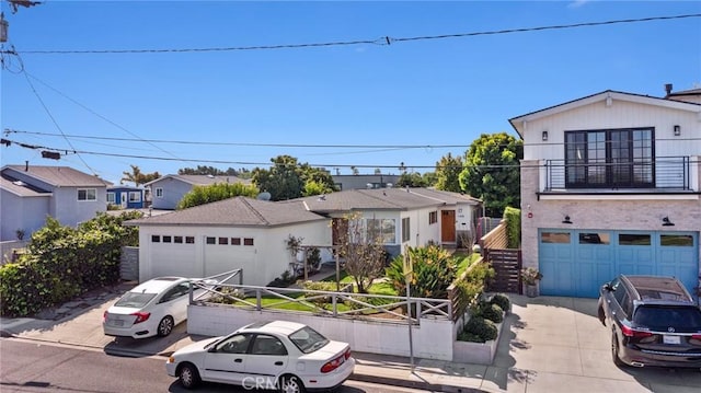 view of front facade with a balcony, a residential view, driveway, and fence