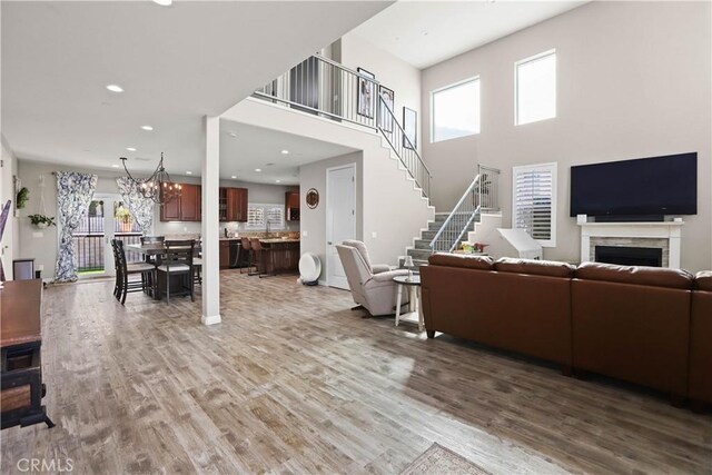 13083 Via Tuscany, Riverside, CA 92503 - living area featuring wood finished floors, healthy amount of natural light, a chandelier, recessed lighting, and a high ceiling