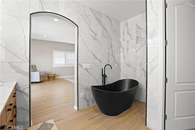 13083 Via Tuscany, Riverside, CA 92503 - bathroom featuring a freestanding tub, wood finished floors, vanity, tile walls, and recessed lighting