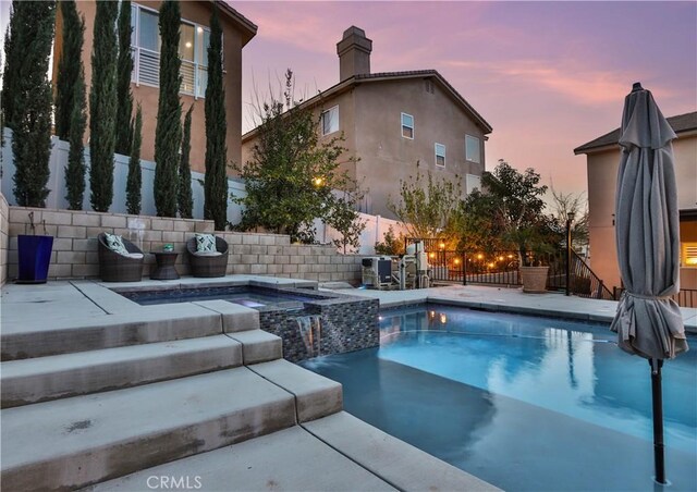 13083 Via Tuscany, Riverside, CA 92503 - pool at dusk with a fenced backyard, a pool with connected hot tub, and a patio