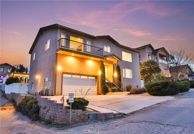 13083 Via Tuscany, Riverside, CA 92503 - view of front of home featuring a balcony, an attached garage, stucco siding, and concrete driveway