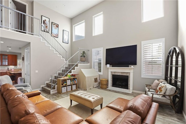 13083 Via Tuscany, Riverside, CA 92503 - living area with a high ceiling, stairway, light wood finished floors, a fireplace with flush hearth, and baseboards