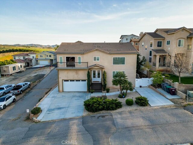 13083 Via Tuscany, Riverside, CA 92503 - view of property featuring a balcony, stucco siding, a residential view, a gate, and driveway