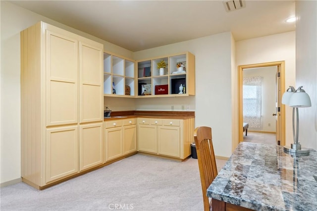 kitchen featuring light carpet, open shelves, and visible vents
