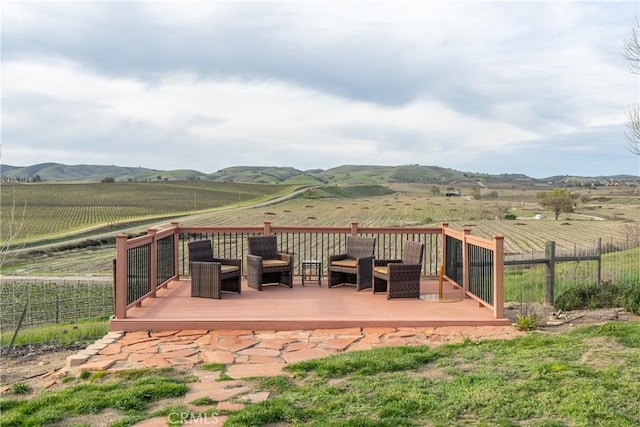 wooden terrace featuring a mountain view, fence, and a rural view