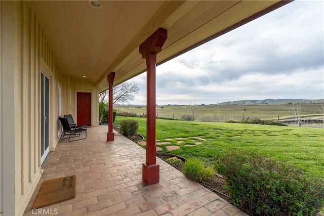view of patio / terrace with a mountain view, a rural view, and fence