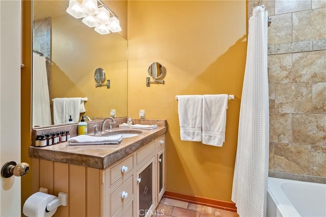 bathroom with baseboards, shower / bath combination with curtain, vanity, and tile patterned floors