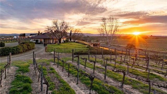 yard at dusk with fence and a rural view