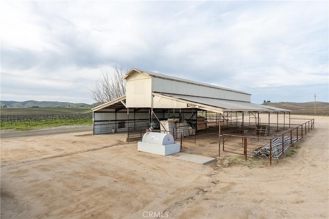 view of outbuilding featuring an outdoor structure, an exterior structure, a mountain view, and a rural view