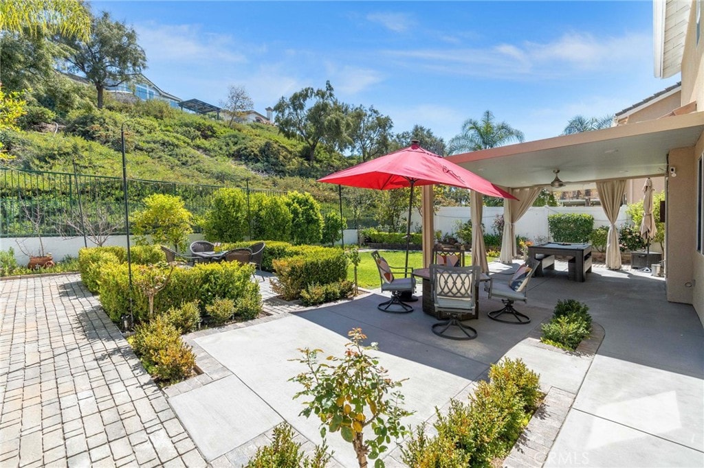 view of patio / terrace with a fenced backyard, outdoor dining space, and a ceiling fan