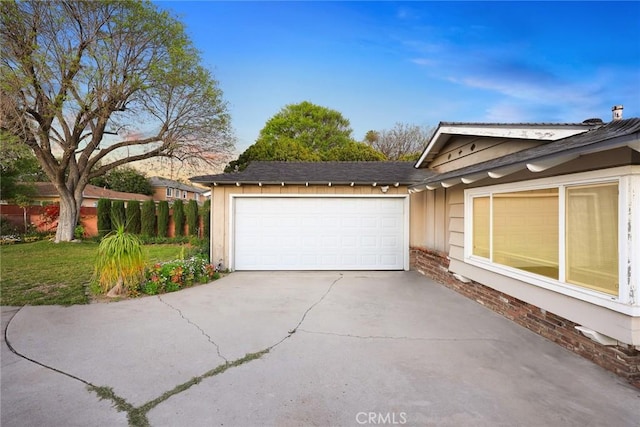 garage featuring concrete driveway