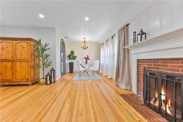 11330 Whitley St, Whittier, CA 90601 - dining space featuring wood finished floors, a chandelier, a brick fireplace, and recessed lighting