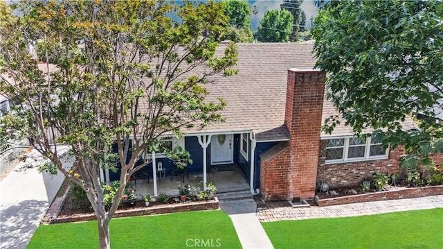 11330 Whitley St, Whittier, CA 90601 - view of front of house featuring a shingled roof, a front yard, a chimney, and brick siding