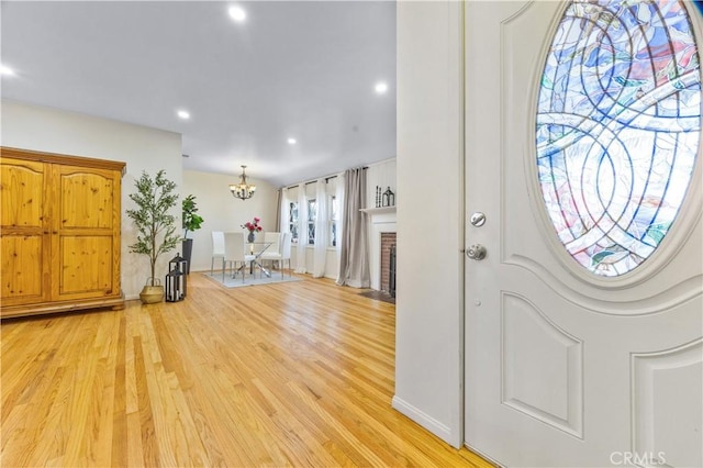 11330 Whitley St, Whittier, CA 90601 - entrance foyer featuring light wood-style flooring, recessed lighting, a brick fireplace, and a chandelier