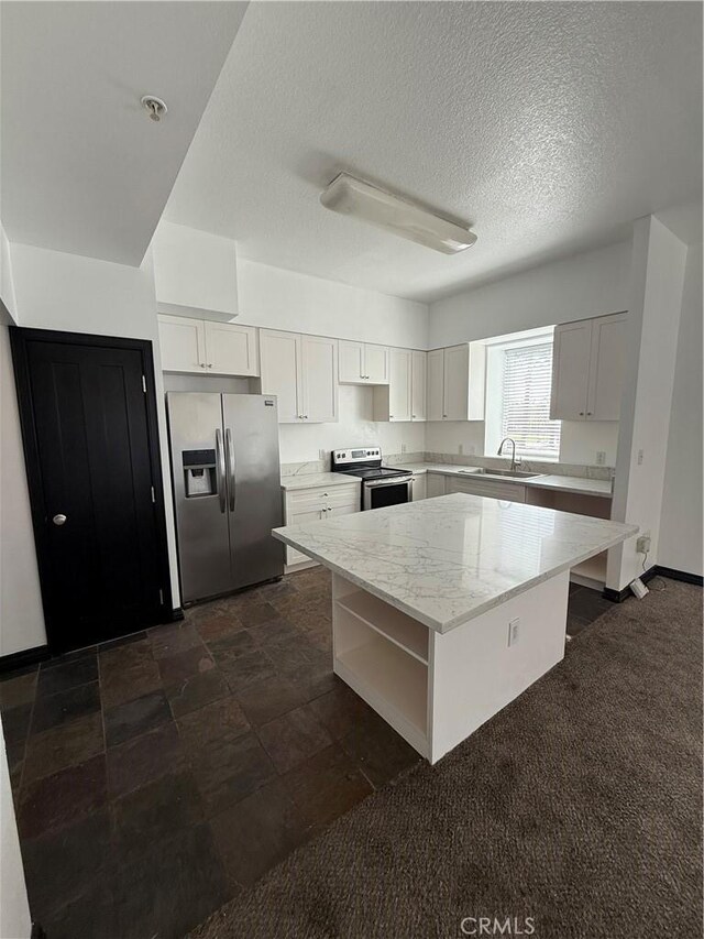 388 E Ocean Blvd Unit 212, Long Beach, CA 90802 - kitchen featuring light stone counters, a sink, white cabinetry, a center island, and stainless steel appliances