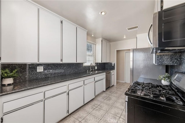 kitchen with white cabinetry, stainless steel appliances, backsplash, a sink, and visible vents