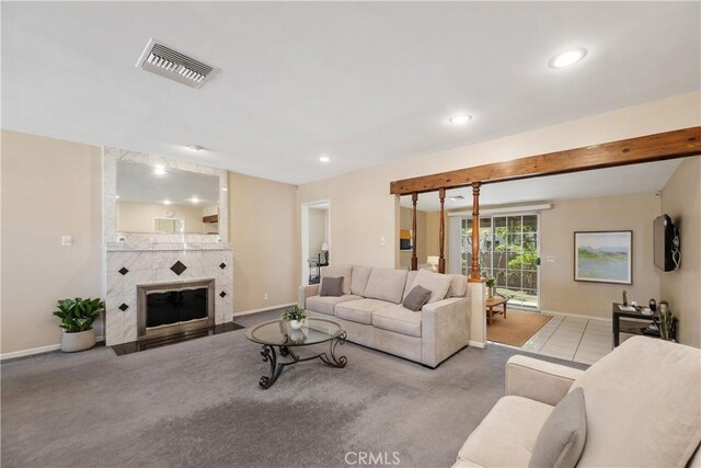 carpeted living area featuring baseboards, visible vents, recessed lighting, and a fireplace