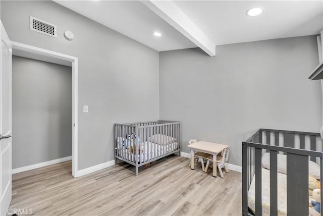 bedroom with beam ceiling, wood finished floors, baseboards, visible vents, and recessed lighting