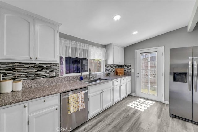 kitchen with white cabinetry, light wood-style floors, stainless steel appliances, and lofted ceiling