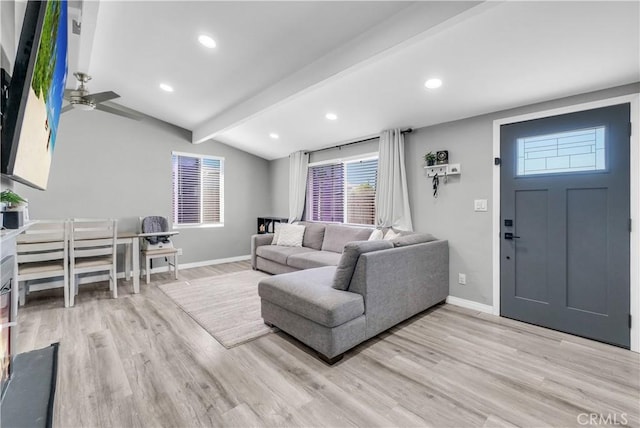living room with a ceiling fan, vaulted ceiling with beams, light wood-style floors, and baseboards