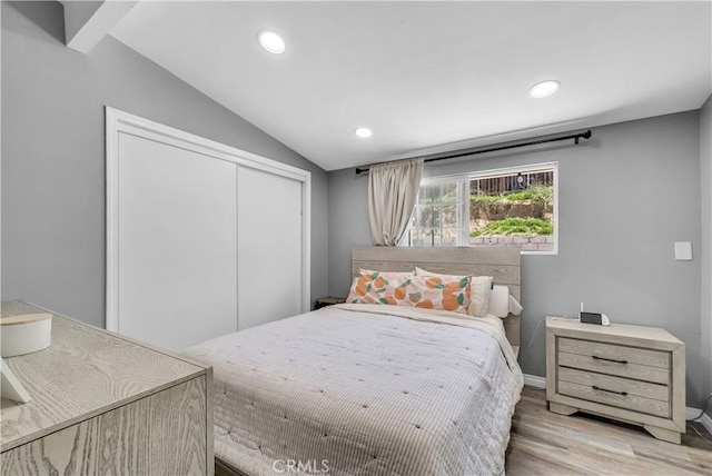 bedroom with vaulted ceiling, a closet, wood finished floors, baseboards, and recessed lighting