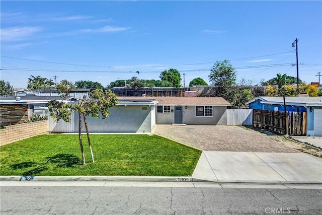 ranch-style home with a front yard, driveway, stucco siding, and fence