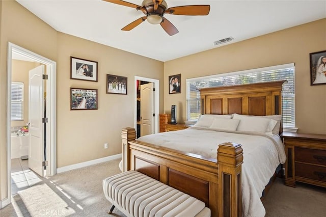 1100 N Ferrocarril Rd, Atascadero, CA 93422 - bedroom with light carpet, baseboards, a walk in closet, a ceiling fan, and ensuite bath