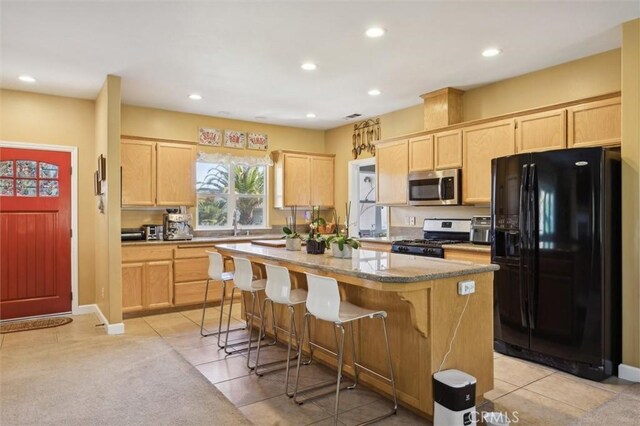 1100 N Ferrocarril Rd, Atascadero, CA 93422 - kitchen with stainless steel appliances, light brown cabinetry, a kitchen island, recessed lighting, and a kitchen bar