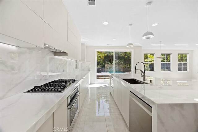 68 Sanctuary, Irvine, CA 92620 - kitchen with stainless steel appliances, a sink, modern cabinets, tasteful backsplash, and a large island with sink