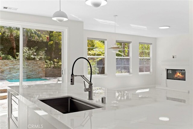 68 Sanctuary, Irvine, CA 92620 - kitchen with a sink, decorative light fixtures, and a glass covered fireplace