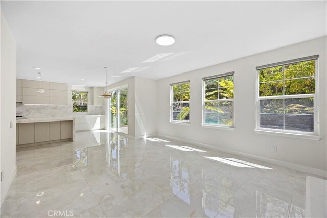 68 Sanctuary, Irvine, CA 92620 - unfurnished living room with light marble finish flooring and baseboards