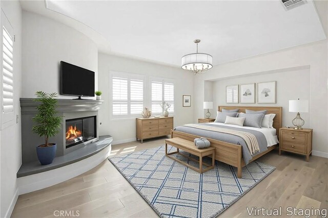 68 Sanctuary, Irvine, CA 92620 - bedroom featuring baseboards, wood finished floors, a chandelier, and a glass covered fireplace