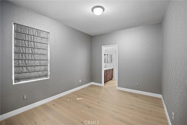 68 Sanctuary, Irvine, CA 92620 - unfurnished room with light wood finished floors, a sink, and baseboards