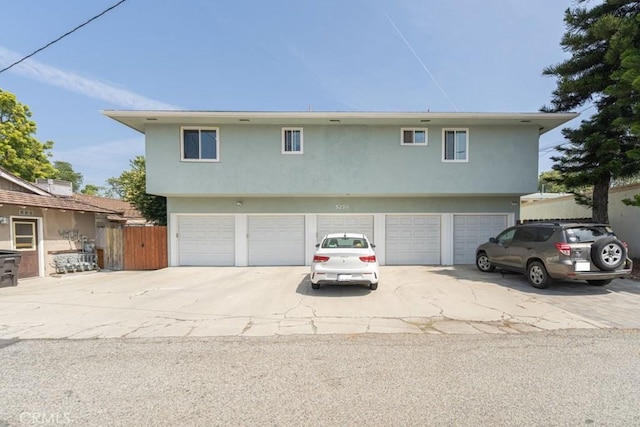 5270 E Anaheim Rd Unit 2, Long Beach, CA 90815 - view of front of house with an attached garage, driveway, stucco siding, and fence