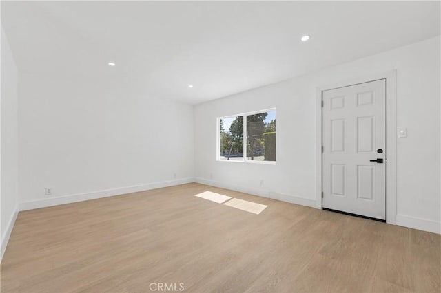 unfurnished room with recessed lighting, baseboards, and light wood-type flooring