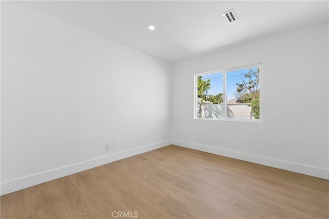 empty room with baseboards, visible vents, recessed lighting, and light wood-type flooring