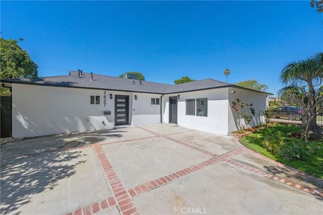 rear view of property with stucco siding, fence, and a patio