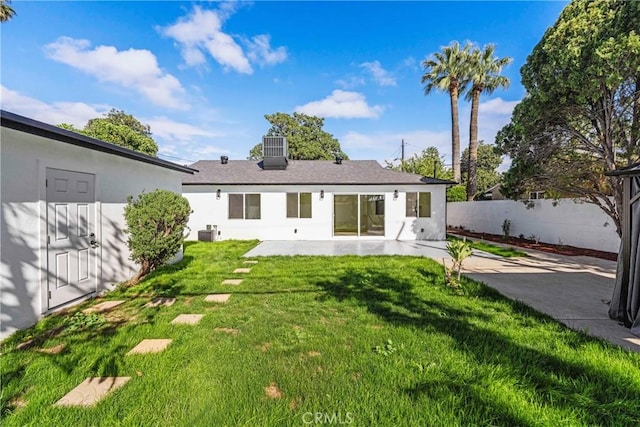 rear view of property with cooling unit, a yard, fence, and a patio area