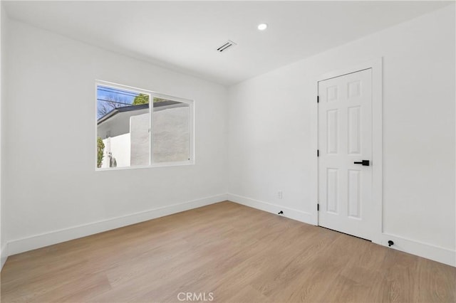 unfurnished room featuring baseboards, visible vents, wood finished floors, and recessed lighting